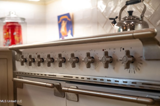 room details featuring decorative backsplash and white range oven