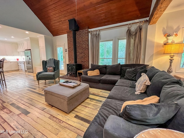 living room featuring high vaulted ceiling, a wood stove, light hardwood / wood-style flooring, and beamed ceiling