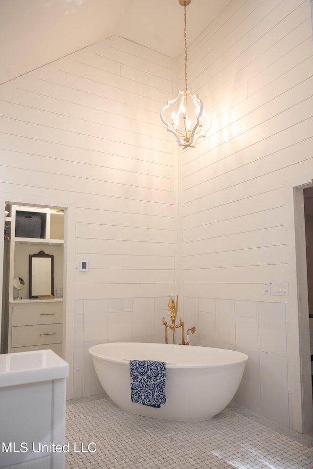 bathroom featuring a tub, tile patterned floors, tile walls, vanity, and high vaulted ceiling