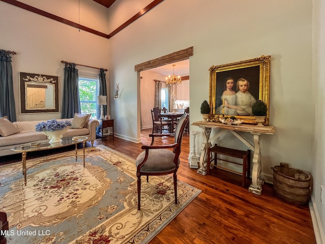 living area featuring a chandelier, dark hardwood / wood-style floors, and a towering ceiling