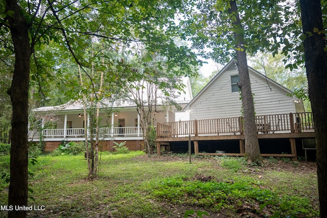 back of house featuring a deck and a lawn