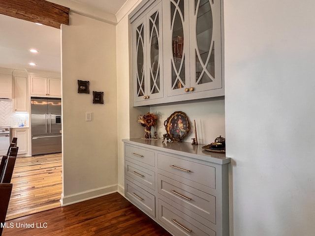 interior space with white cabinets, beam ceiling, tasteful backsplash, high end refrigerator, and dark hardwood / wood-style floors