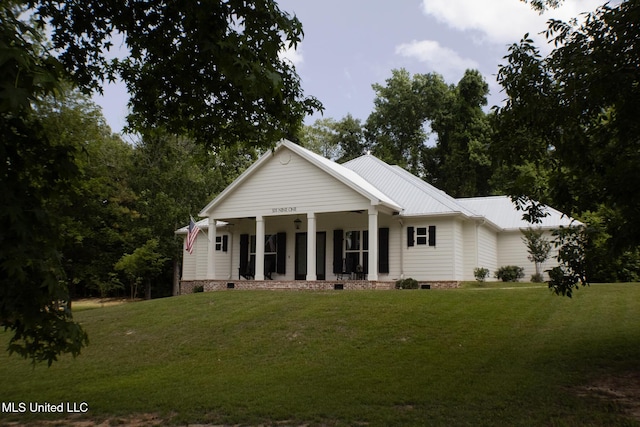 691 Apona St, Diamondhead, MS 39525 - view of front of house with crawl space, a front lawn, covered porch, and metal roof
