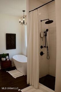 691 Apona St, Diamondhead, MS 39525 - full bath with a chandelier, tiled shower, and a soaking tub