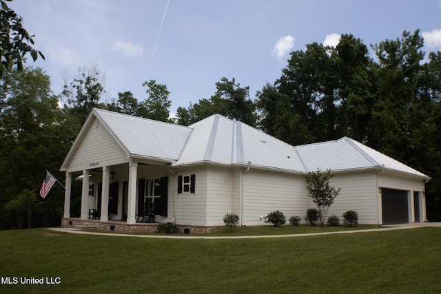 691 Apona St, Diamondhead, MS 39525 - view of front of property featuring a porch, a front yard, an attached garage, and metal roof
