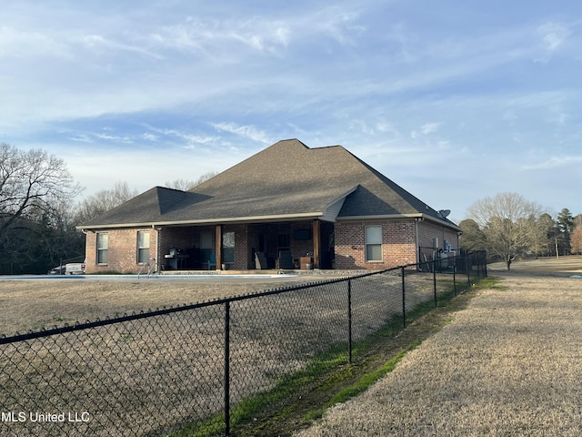 view of front of property featuring a front yard, brick siding, and fence