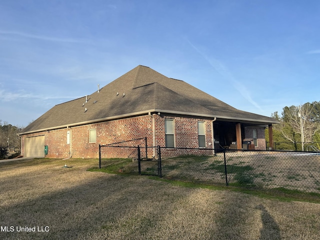 view of property exterior with a garage, brick siding, a shingled roof, fence, and a lawn