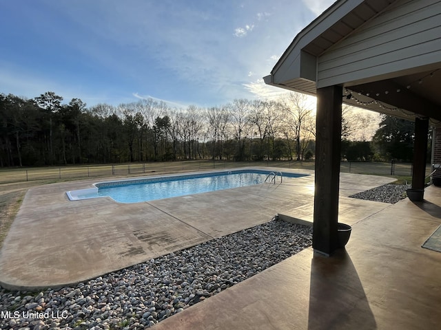 outdoor pool featuring a patio and fence