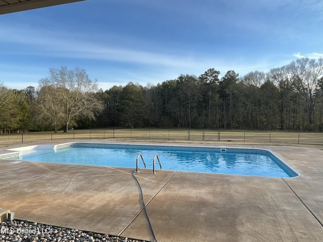 outdoor pool with fence and a patio