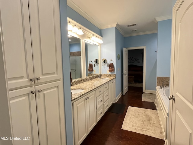 ensuite bathroom featuring a sink, visible vents, ornamental molding, a bath, and double vanity