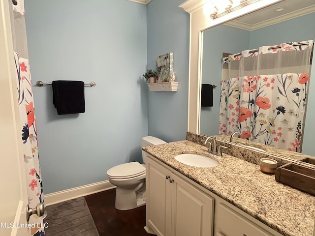 bathroom featuring toilet, ornamental molding, vanity, wood finished floors, and baseboards