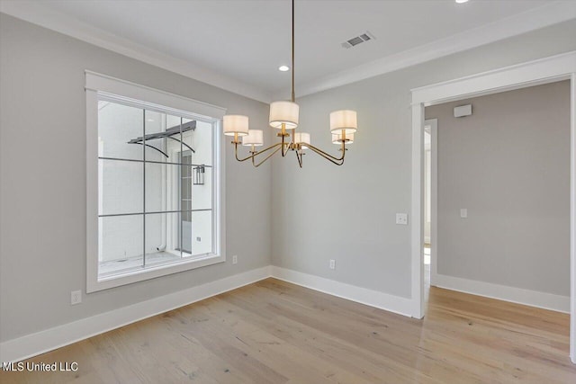 unfurnished dining area with an inviting chandelier, hardwood / wood-style floors, and crown molding