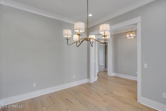 unfurnished dining area featuring ornamental molding and light hardwood / wood-style flooring