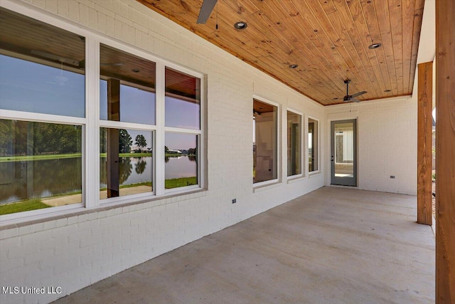 view of patio / terrace featuring a water view and ceiling fan