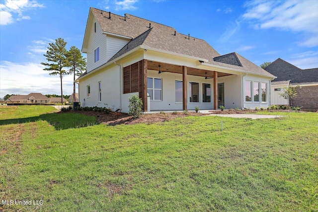 rear view of property with a lawn and ceiling fan