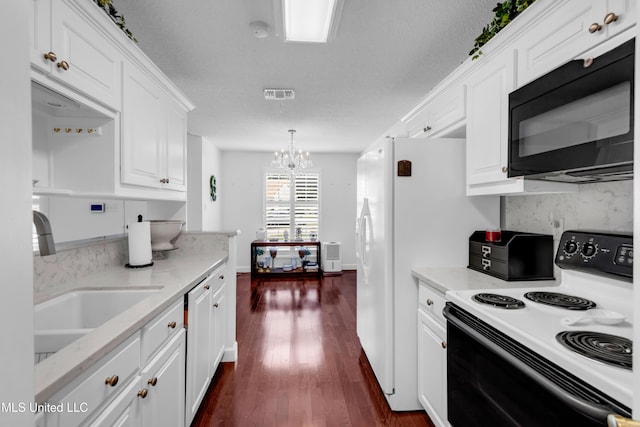 2390 Carter Rd, Biloxi, MS 39531 - kitchen with electric range oven, black microwave, white cabinets, dark wood finished floors, and backsplash