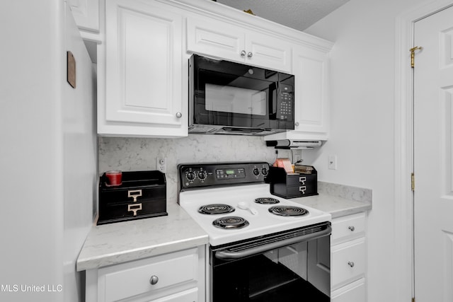 2390 Carter Rd, Biloxi, MS 39531 - kitchen featuring freestanding refrigerator, electric stove, black microwave, white cabinets, and tasteful backsplash