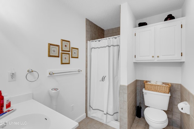 2390 Carter Rd, Biloxi, MS 39531 - bathroom featuring vanity, toilet, tile walls, curtained shower, and a textured ceiling