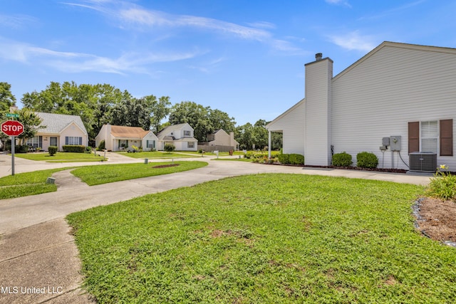 2390 Carter Rd, Biloxi, MS 39531 - view of green lawn featuring curved driveway, central AC, and a residential view