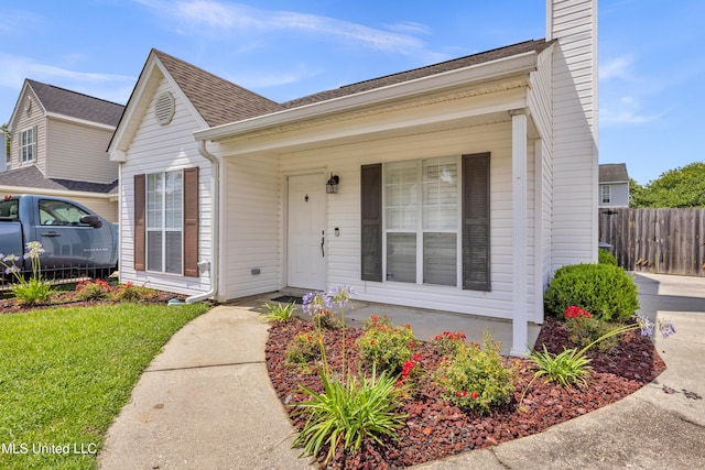 2390 Carter Rd, Biloxi, MS 39531 - view of front facade with covered porch, a shingled roof, and a chimney