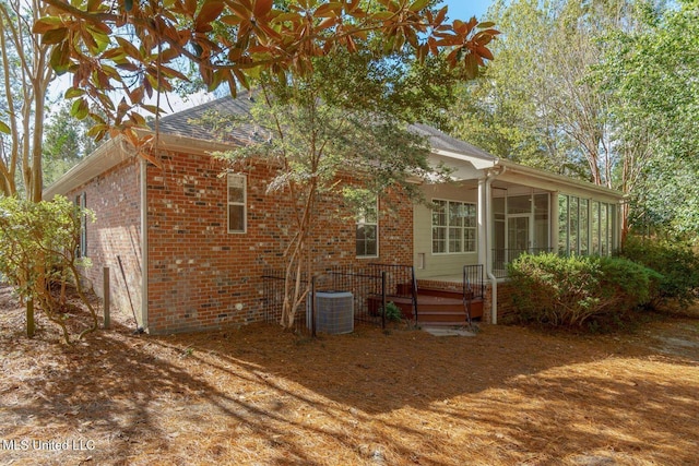 54 Saint Annes Dr, Hattiesburg, MS 39401 - rear view of house featuring brick siding, a sunroom, and a shingled roof