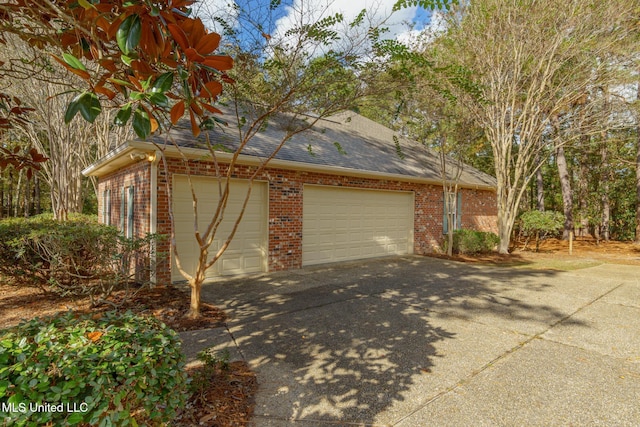 54 Saint Annes Dr, Hattiesburg, MS 39401 - view of side of home featuring brick siding, concrete driveway, an attached garage, and roof with shingles