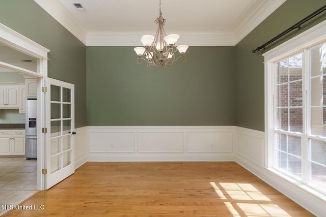54 Saint Annes Dr, Hattiesburg, MS 39401 - unfurnished dining area featuring a chandelier, light wood-style floors, crown molding, and a wainscoted wall