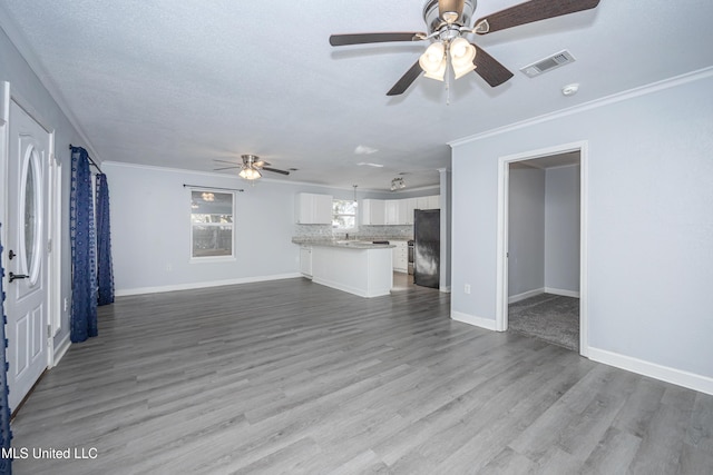 unfurnished living room with ceiling fan, crown molding, a textured ceiling, and hardwood / wood-style flooring