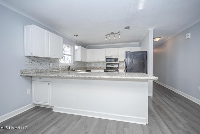 kitchen with kitchen peninsula, appliances with stainless steel finishes, pendant lighting, and white cabinetry