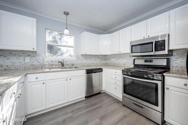 kitchen featuring hanging light fixtures, appliances with stainless steel finishes, sink, and white cabinetry