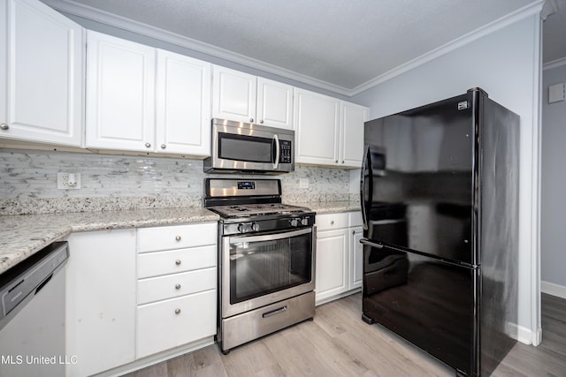 kitchen with tasteful backsplash, appliances with stainless steel finishes, and white cabinetry