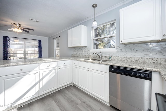 kitchen featuring light wood-type flooring, dishwasher, hanging light fixtures, white cabinets, and sink