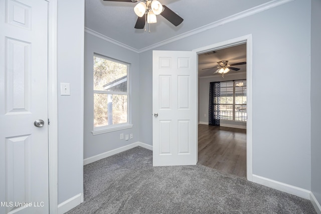 carpeted spare room with ceiling fan and ornamental molding