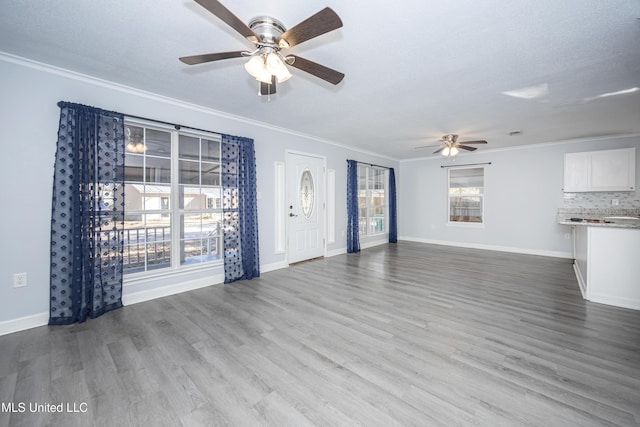 unfurnished living room featuring light wood-type flooring, ceiling fan, crown molding, and a textured ceiling