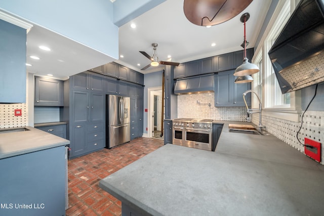 905 Franklin St, Corinth, MS 38834 - kitchen with appliances with stainless steel finishes, wall chimney exhaust hood, a sink, brick floors, and ceiling fan