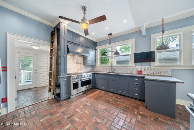 905 Franklin St, Corinth, MS 38834 - kitchen with range with two ovens, wall chimney exhaust hood, ornamental molding, gray cabinetry, and a ceiling fan