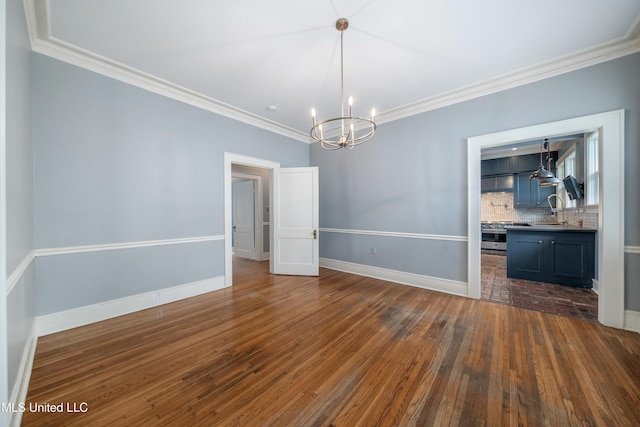905 Franklin St, Corinth, MS 38834 - empty room featuring a chandelier, a sink, crown molding, baseboards, and dark wood finished floors