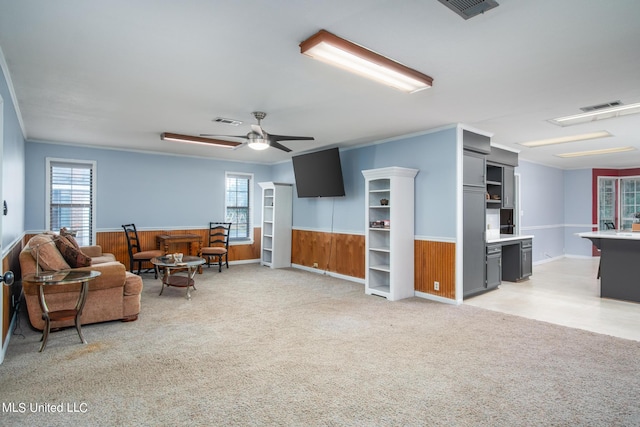 living room featuring a wainscoted wall, plenty of natural light, and visible vents