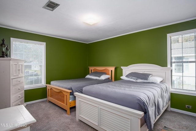 carpeted bedroom with visible vents, baseboards, and ornamental molding