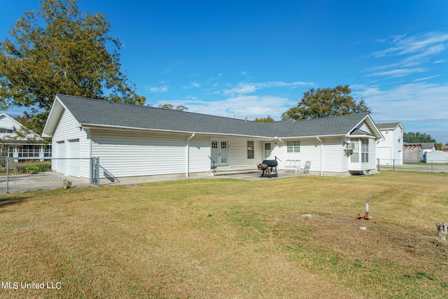 rear view of property featuring a patio, fence, a yard, french doors, and a garage