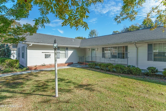 ranch-style house with roof with shingles and a front lawn