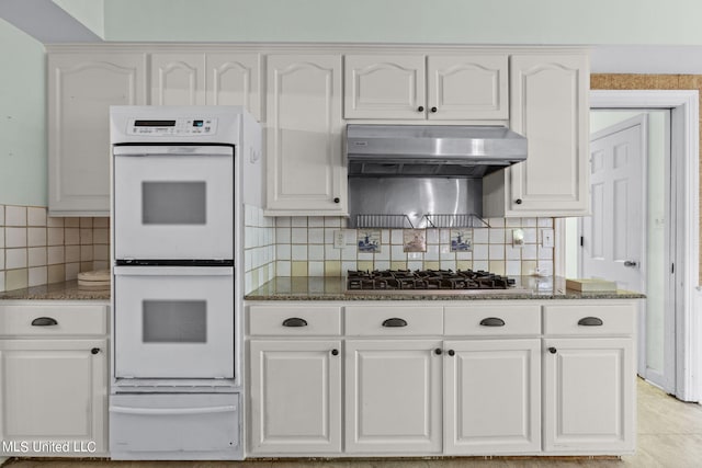 kitchen featuring white cabinetry, decorative backsplash, stainless steel gas stovetop, and double oven