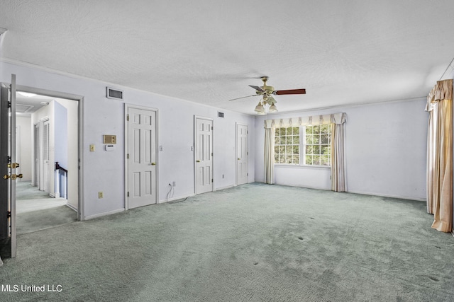 carpeted spare room featuring a textured ceiling and ceiling fan