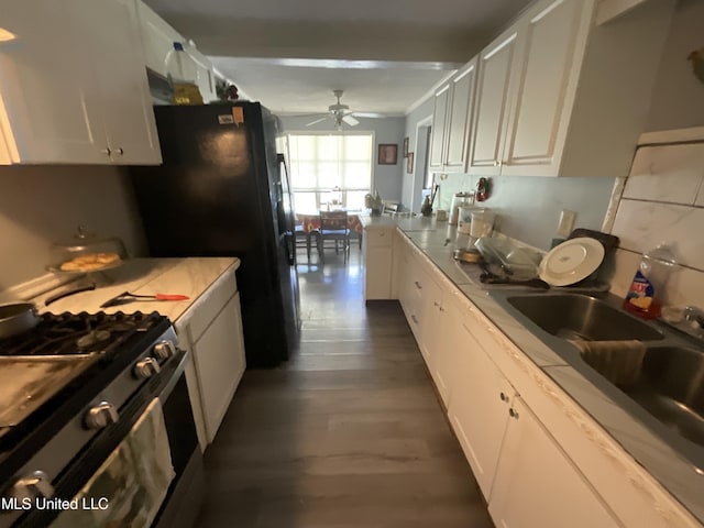 260 SCR 62, Magee, MS 39111 - kitchen with gas range, ceiling fan, white cabinetry, dark wood-style floors, and freestanding refrigerator