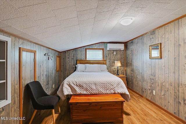 bedroom with lofted ceiling, a wall unit AC, wood-type flooring, and wood walls