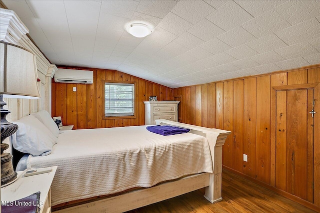 bedroom with lofted ceiling, wood walls, hardwood / wood-style flooring, and an AC wall unit