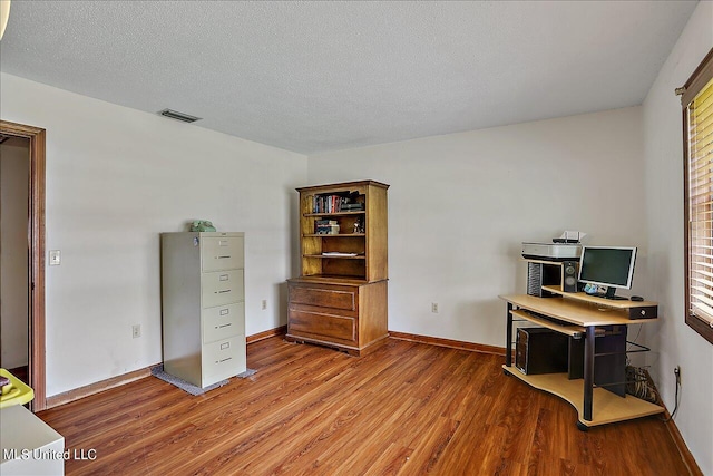 office area with a textured ceiling and hardwood / wood-style floors