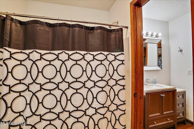 bathroom featuring vanity, a textured ceiling, and a shower with shower curtain