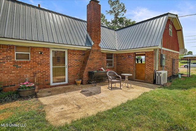 rear view of house with a patio, central air condition unit, and a lawn