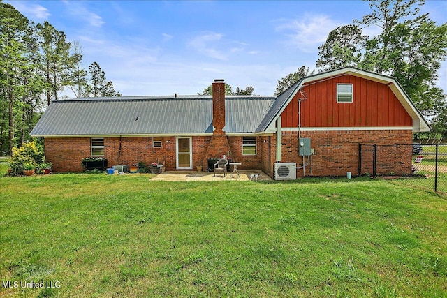 back of property with ac unit, a patio area, and a yard